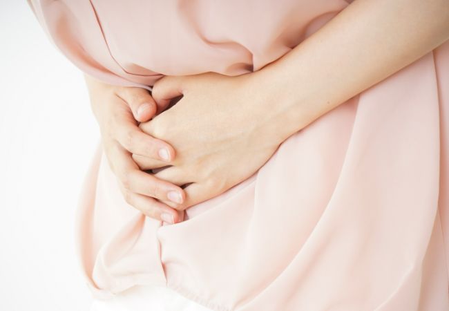 お腹を抑える女性